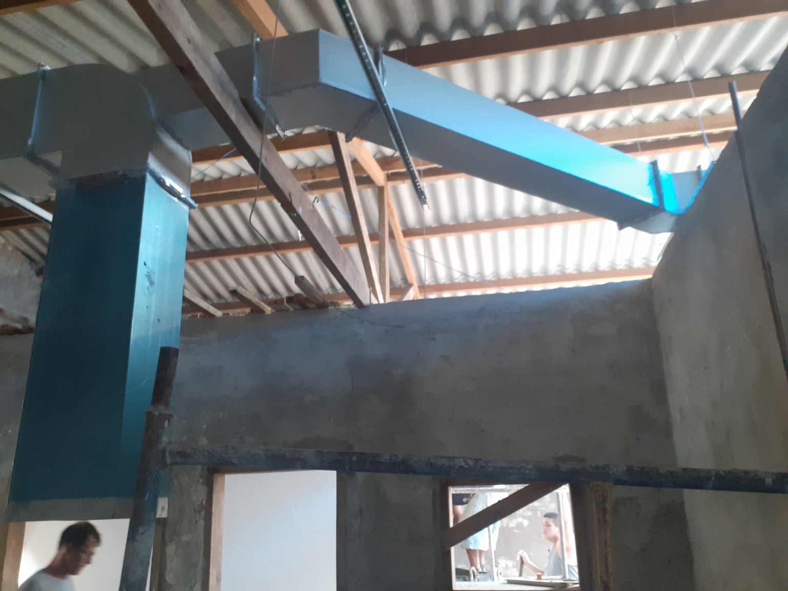 Rede retangular de dutos de exaustão sendo instalada junto ao telhado